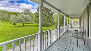 A covered porch with a view of a green lawn and trees. - Pet-friendly Pond View Loft' w/ Private Pool! (Pine Bush)