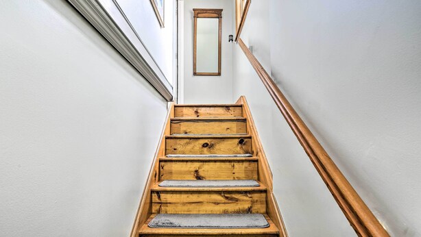A wooden staircase with a handrail, a small mirror on the wall, and a door at the top. - Pet-friendly Pond View Loft' w/ Private Pool! (Pine Bush)