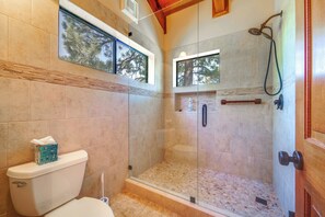 A modern bathroom with a glass-enclosed shower, a toilet, and a window providing a view of trees. - Shuttle to Ski Resort: Northstar Home! (Truckee)