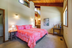 A bedroom with a large bed, a nightstand, a lamp, a dresser, a mirror, and a window with a view of the outside. - Shuttle to Ski Resort: Northstar Home! (Truckee)
