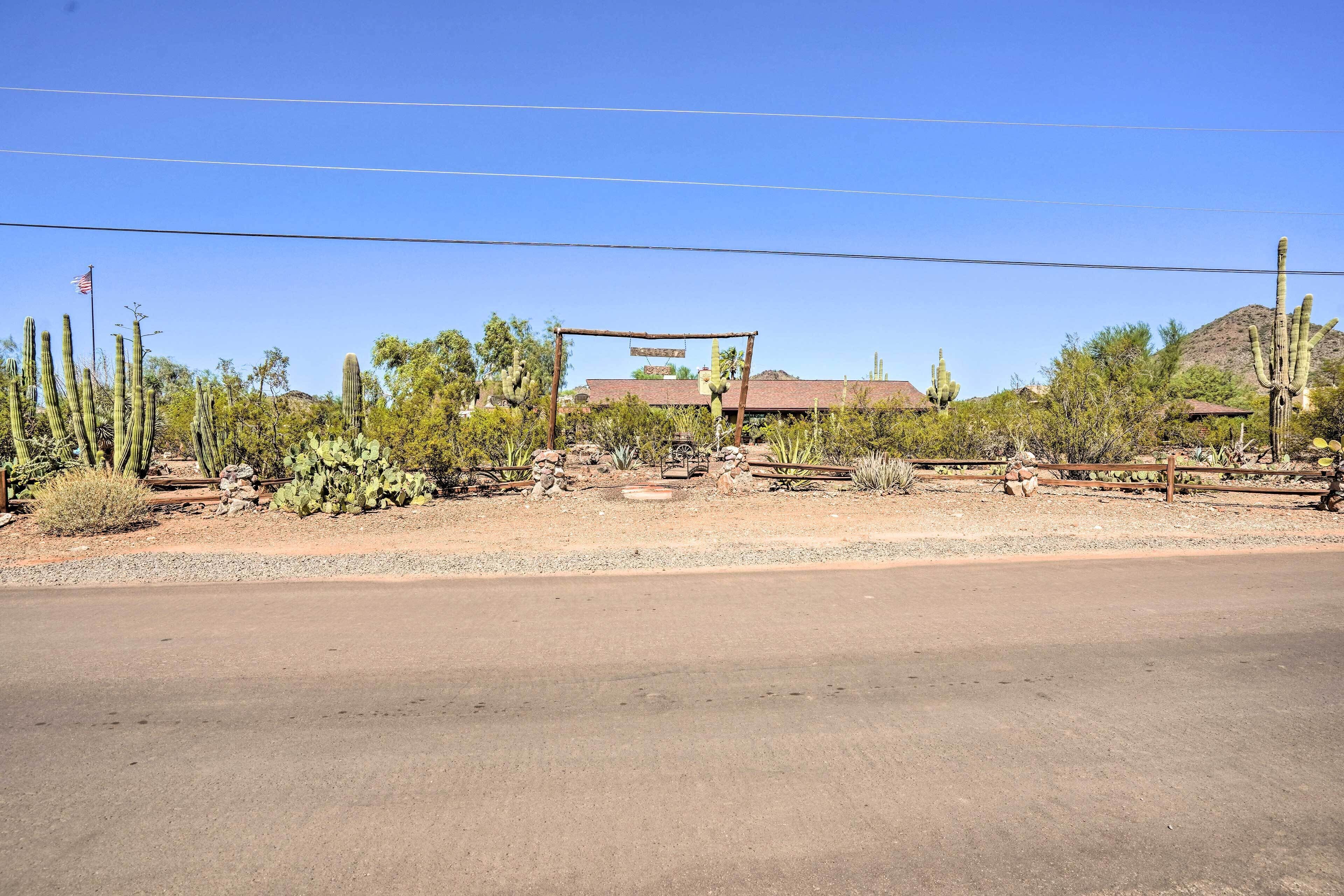 A desert landscape with cacti and a wooden structure.