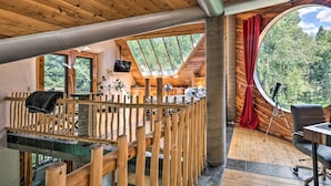 A wooden cabin interior with a loft bed, a telescope, and a dining area. - Angel Fire Cabin w/ Deck ~ 2 Mi to Ski & Hiking! (Angel Fire)