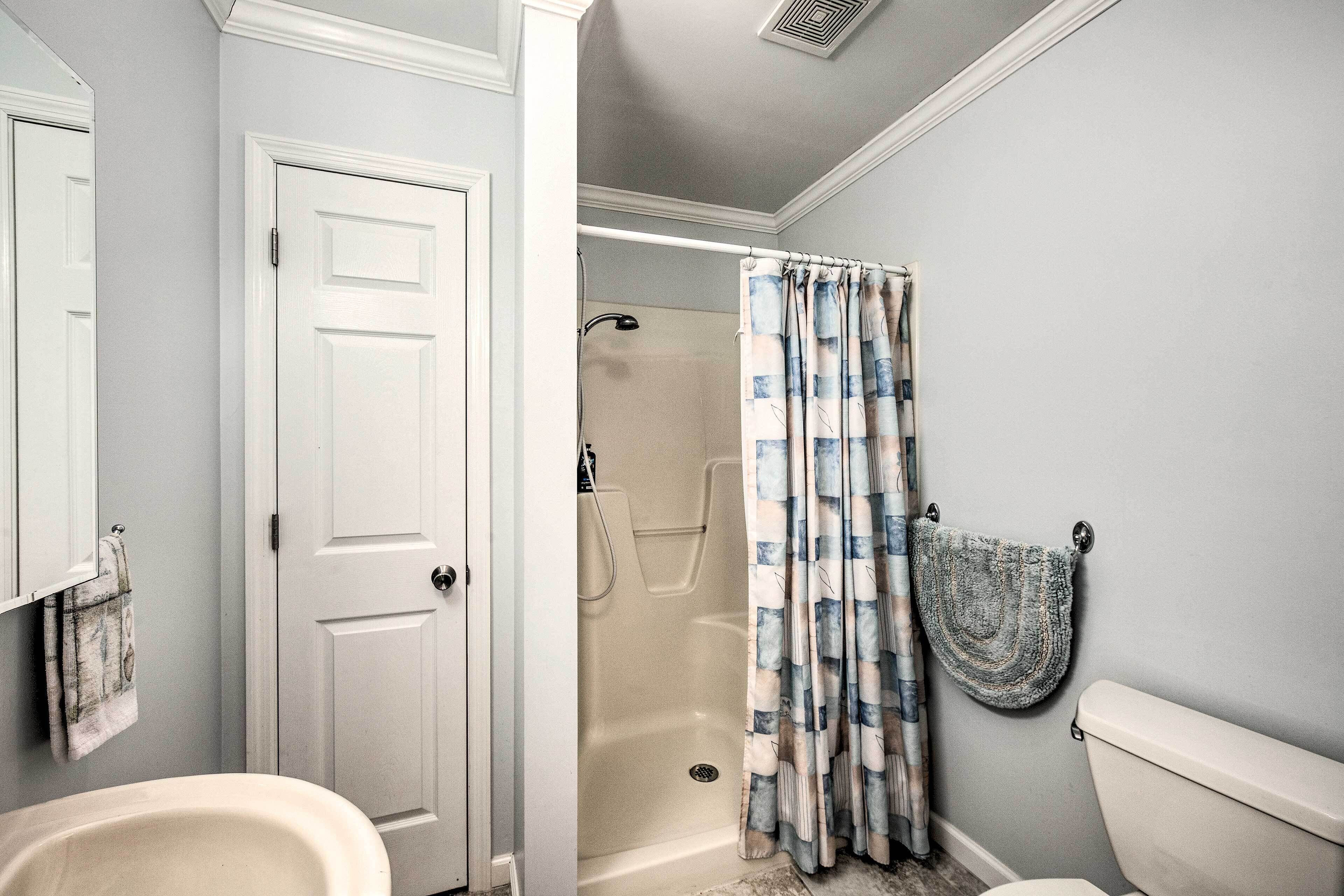 A bathroom with a bathtub, toilet, and shower curtain.