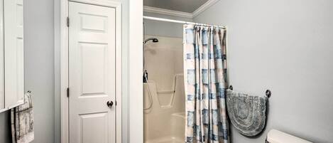 A bathroom with a bathtub, toilet, and shower curtain.
