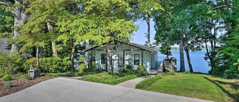 A house with a front yard, a driveway, and a view of a lake.