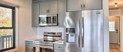 A modern kitchen with stainless steel appliances, a built-in oven, and a microwave.