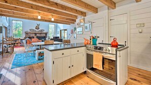 A rustic kitchen with wooden beams, a central island, and a fireplace.