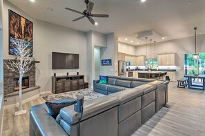 Ein modernes Wohnzimmer mit Ecksofa, Kamin und Flachbildfernseher.