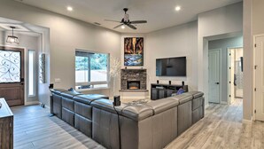 A modern living room with a large sectional sofa, a fireplace, and a flat-screen TV. - Sedona Retreat w/ Patio, Bar & Swim Spa! (Sedona)