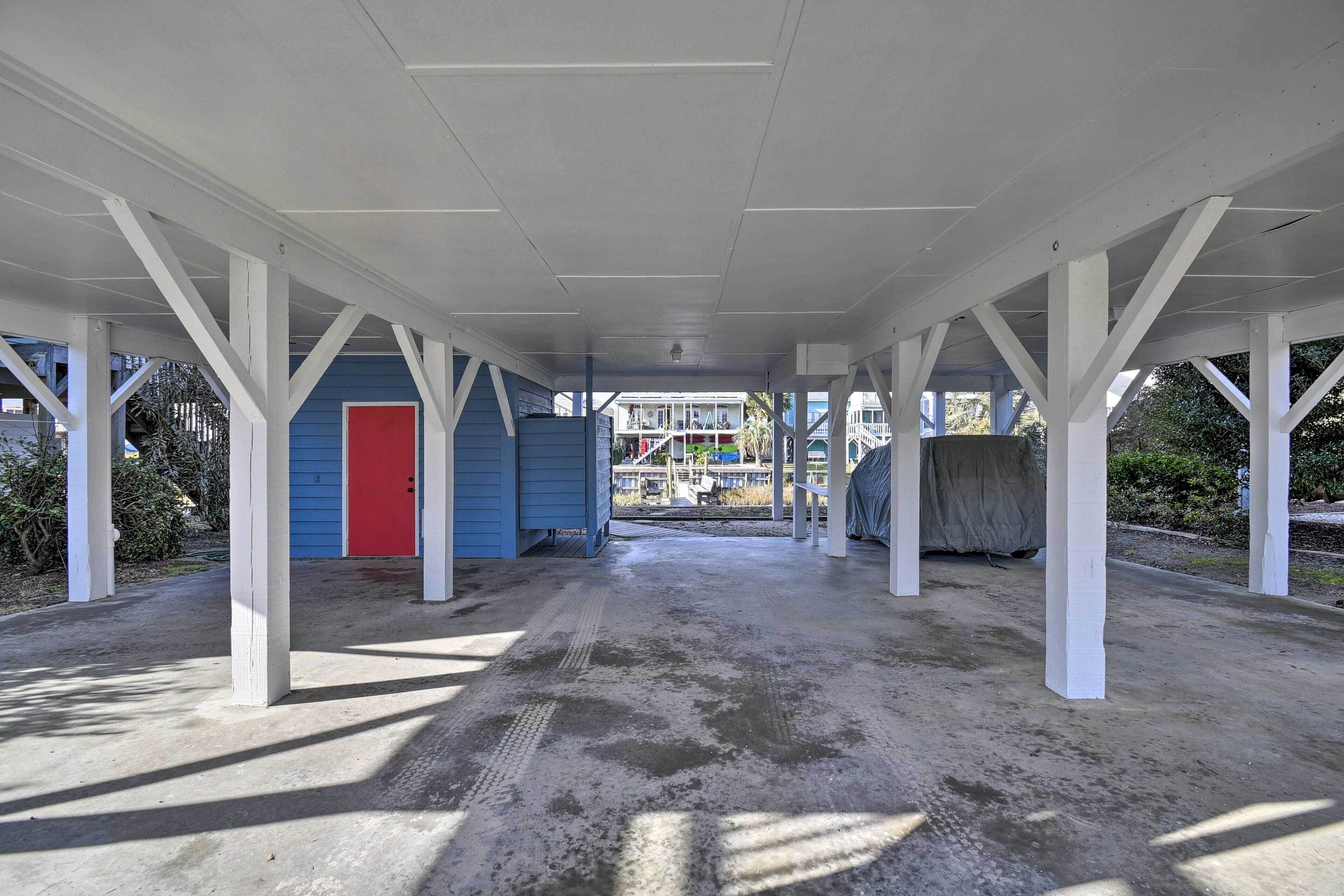 An open covered area with concrete flooring and white structural beams.