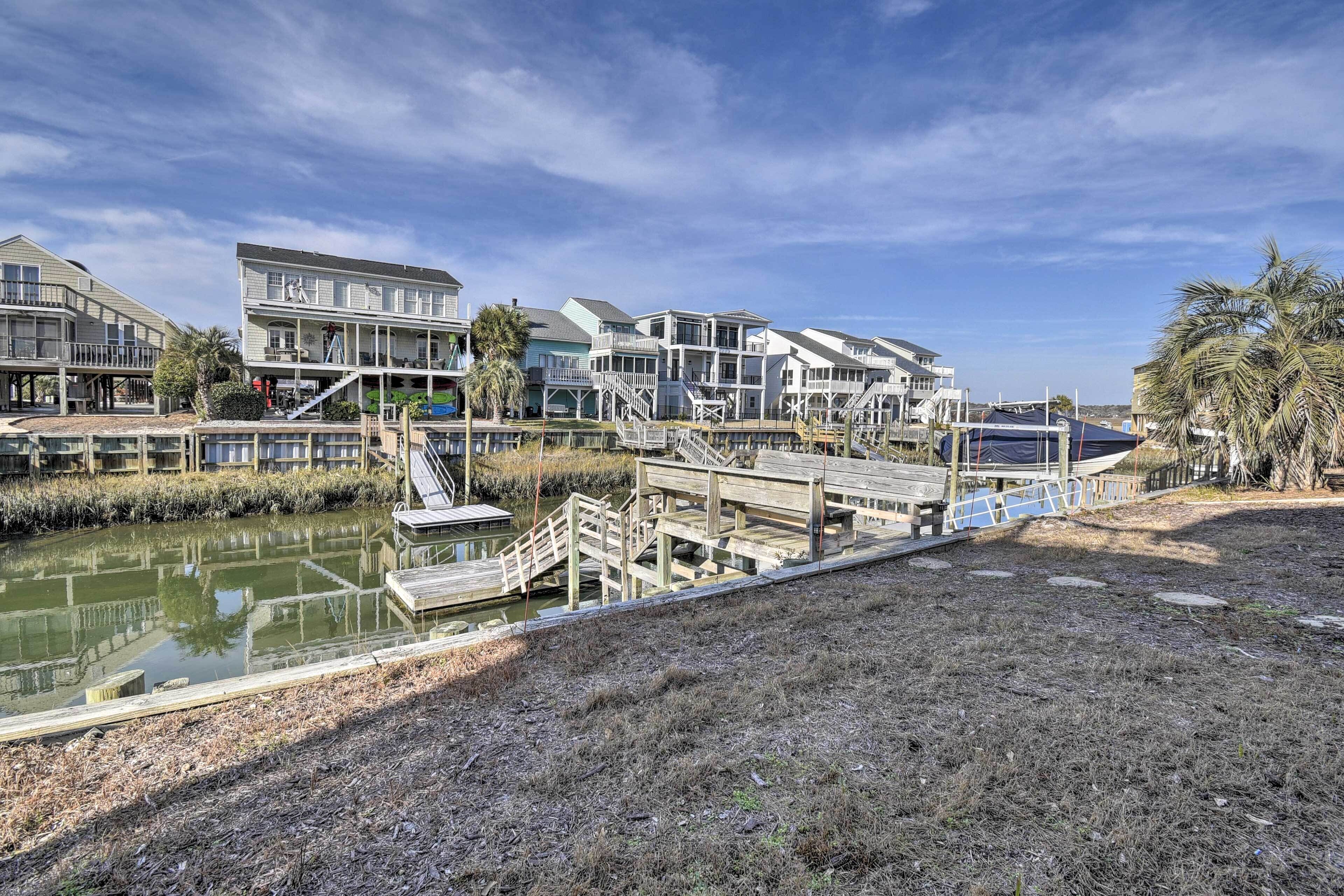 A waterfront property with multiple buildings, a dock, and a small boat.