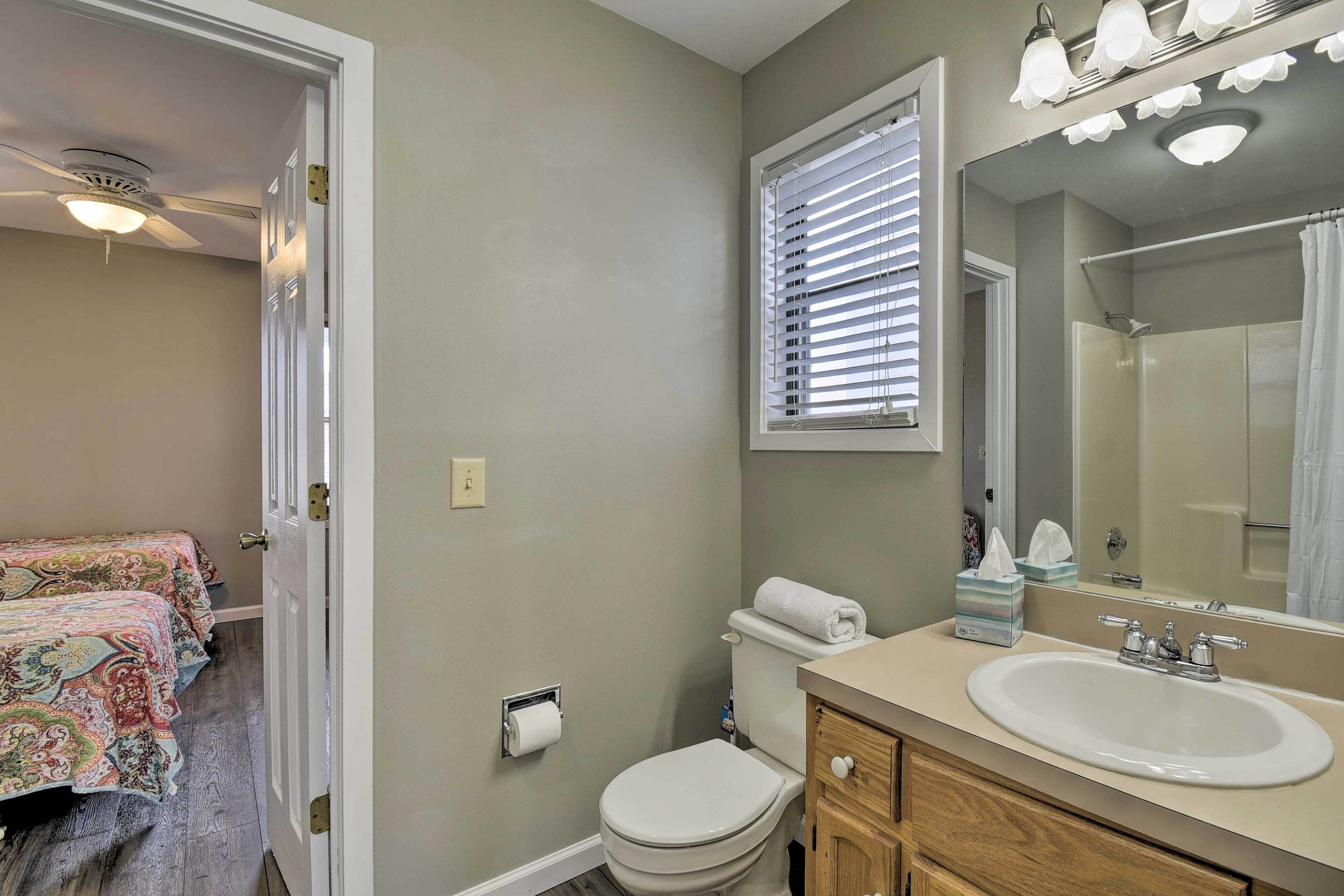 A bathroom with a toilet, sink, and mirror.