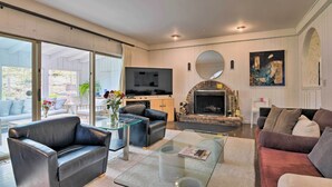 Una sala de estar moderna con chimenea, televisor de pantalla plana y asientos cómodos.