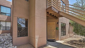 A modern building with a beige exterior, a wooden door, and a staircase leading to an upper level. - Tucson Desert Retreat w/ Pool + Hot Tub Access! (Tucson)