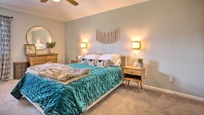 A bedroom with a bed, nightstands, a dresser, a ceiling fan, a mirror, and wall sconces. - Pet-friendly Bryan Home < 5 Mi to Texas A & M! (Bryan)