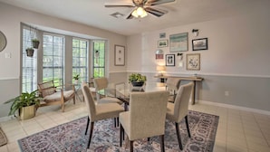 A dining area with a glass table, four chairs, a ceiling fan, and a patterned rug. - Pet-friendly Bryan Home < 5 Mi to Texas A & M! (Bryan)