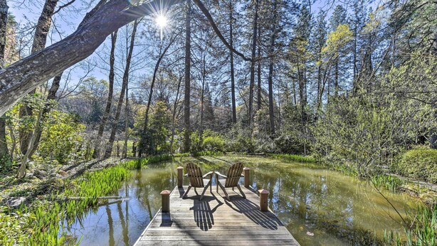 A wooden dock extending into a pond surrounded by trees, with two chairs facing each other. - Peaceful Cottage w/ Grill & Yard in Grass Valley! (Grass Valley)