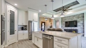 A modern kitchen with white cabinetry, stainless steel appliances, and pendant lighting. - Picturesque Texas Gulf Coast Home in Port Isabel! (Port Isabel)
