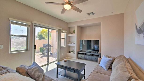 A living room with a sofa, coffee table, TV, and a ceiling fan. - Goodyear Escape w/ Grill: Community Pool Access! (Goodyear)