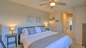 A bedroom with a bed, bedside tables with lamps, a ceiling fan, and artwork on the wall. - Goodyear Escape w/ Grill: Community Pool Access! (Goodyear)
