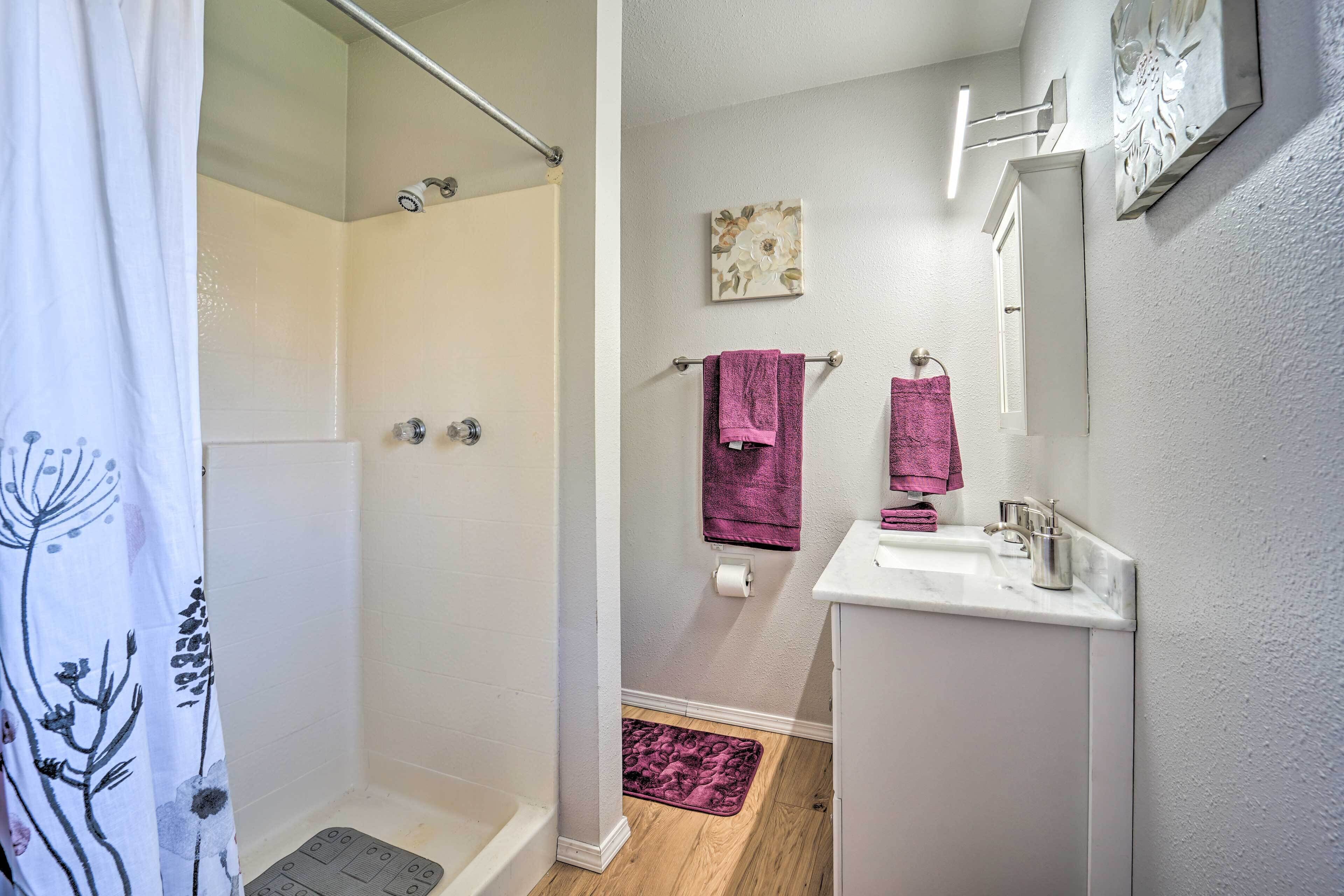 Une salle de bain avec une douche, un lavabo et des toilettes.