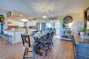 A spacious kitchen with a central island, wooden flooring, and modern appliances.