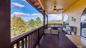 A wooden deck with a table and chairs, a grill, and a view of trees and mountains. - Game Room + Mtn-view Deck: Prescott Escape! (Prescott)