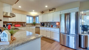 A modern kitchen with white cabinets, a stainless steel refrigerator, and a granite countertop. - Game Room + Mtn-view Deck: Prescott Escape! (Prescott)
