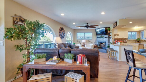 A spacious living room with a large sofa, a wooden coffee table, and a dining area with a bar. - Game Room + Mtn-view Deck: Prescott Escape! (Prescott)