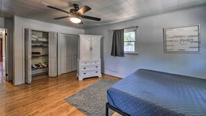 A bedroom with a bed, a wardrobe, a ceiling fan, and a window. - 'the Grey Goose': Waterfront Home With Beach (New Bern)