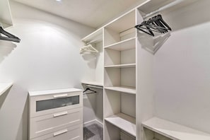 A white closet with open shelves and hanging space.