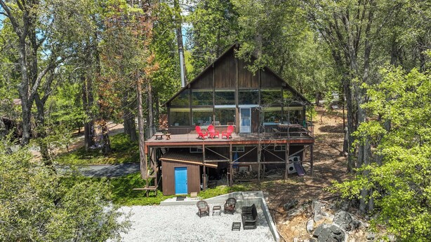 A cabin with a large deck, surrounded by trees. - Hike, Bike & Golf: Peaceful Cabin in Twain Harte! (Twain Harte)