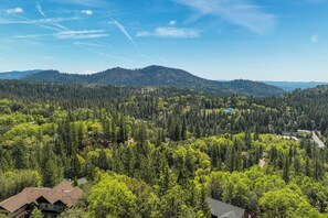 A forested mountain landscape with a house surrounded by trees. - Hike, Bike & Golf: Peaceful Cabin in Twain Harte! (Twain Harte)