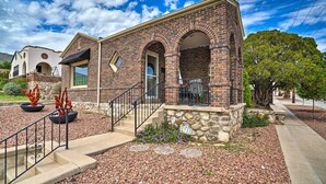 A brick building with a stone foundation, a front entrance, and a staircase leading to the door.