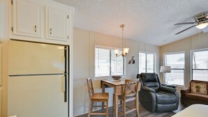 A compact kitchen with a refrigerator, dining table, chairs, and a ceiling fan. - Pet-friendly Vacation Rental in Yuma With Grill! (Yuma)