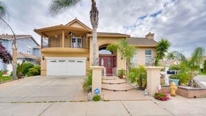 A two-story house with a front porch, a garage, and a well-maintained lawn. - Luxe Atwater Home w/ Patio: 10 Mi to Yosemite Lake (Atwater)