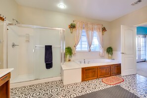 A bathroom with a glass shower enclosure, a white bathtub, and patterned floor tiles. - Luxe Atwater Home w/ Patio: 10 Mi to Yosemite Lake (Atwater)