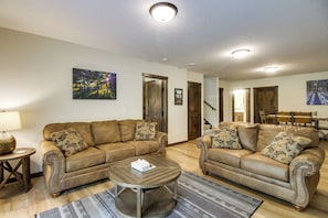 A living room with two brown leather sofas, a wooden coffee table, and a patterned rug. - Gull Lake Winter Escape: Hot Tub & ORV Trails (Nisswa)