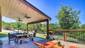 A covered outdoor deck with a table, chairs, and a lounge chair. - Game Room + 1-acre Yard! Lake Travis Retreat (Leander)