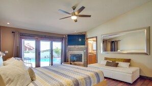 Un dormitorio con una cama grande, un sofá, un televisor y una chimenea.