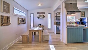Une cuisine moderne dotée d’un îlot central intégré, de revêtements de sol en bois et d’un coin repas avec un banc.