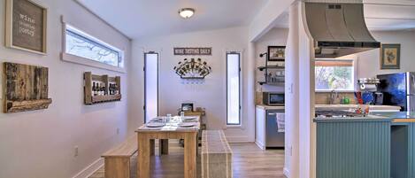 A modern kitchen with a built-in island, wooden flooring, and a dining area with a bench.