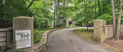 A pathway leading to a building with a sign for The White Elephant Inn.