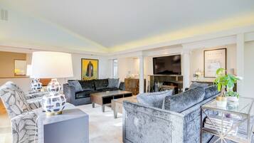 A modern living room with a grey sofa, a coffee table, and patterned chairs.