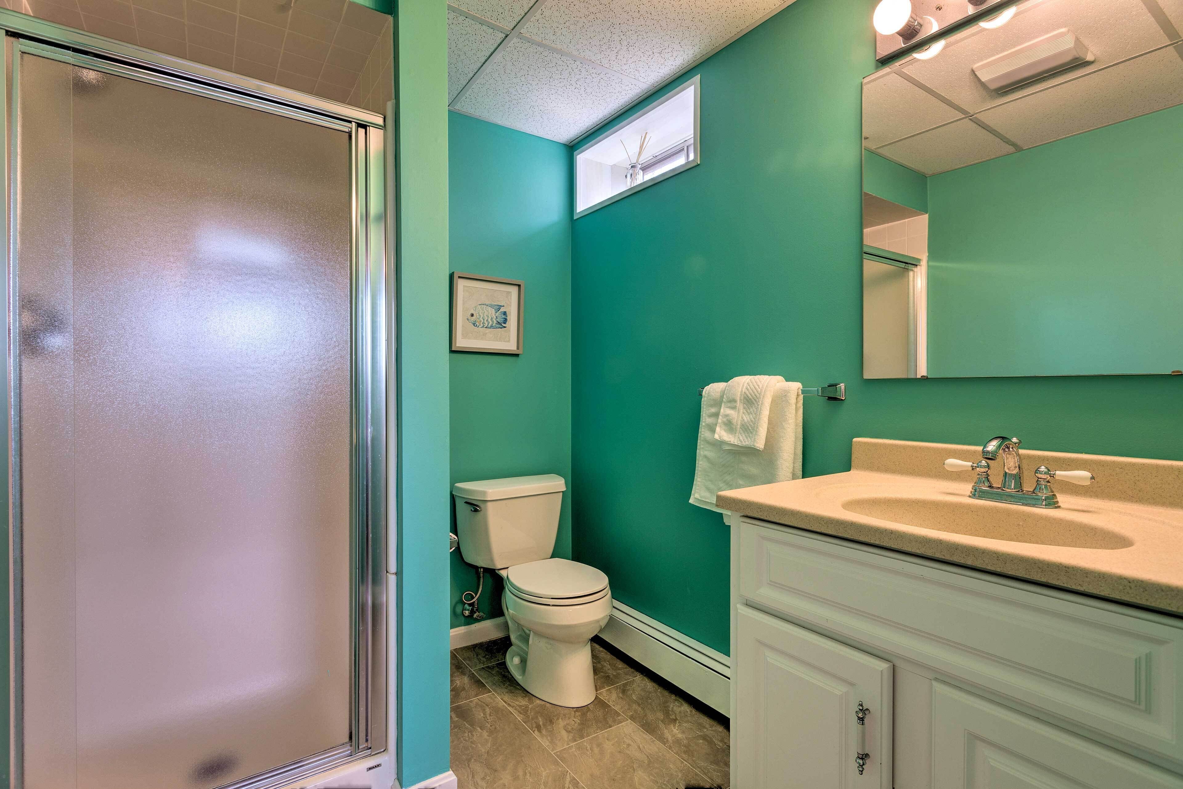 A bathroom with a shower, toilet, and sink.