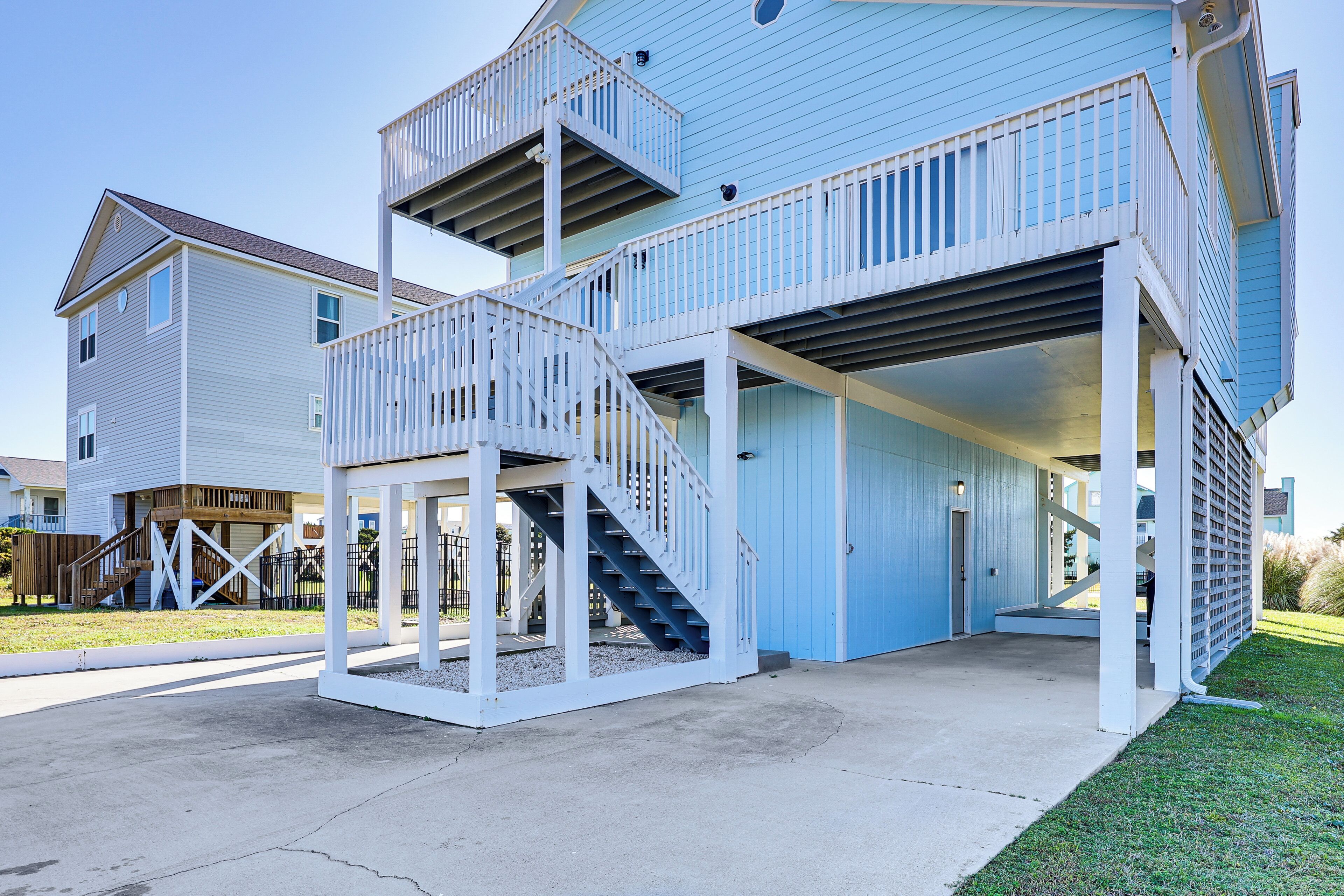 A two-story house with a covered porch and a staircase leading to a balcony.