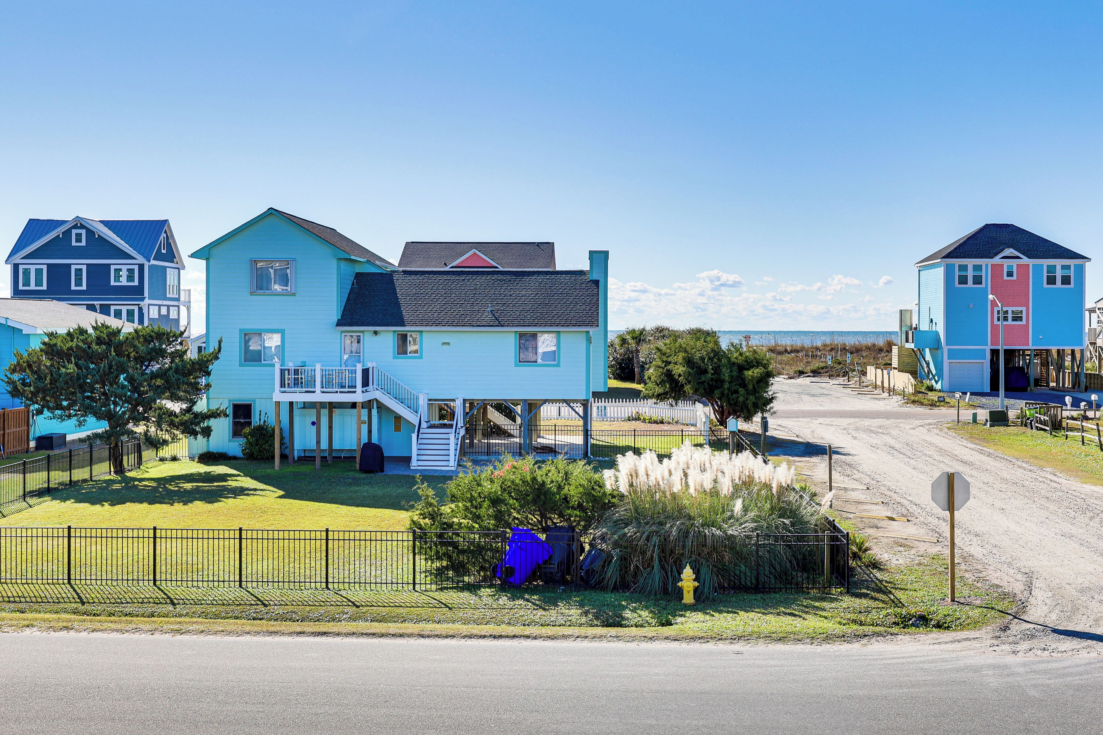 Un quartier résidentiel situé sur la côte, où les maisons sont dotées de balcons et offrent une vue dégagée sur la plage.