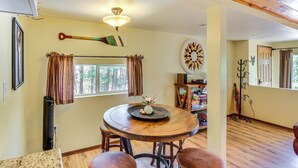 Un coin repas comprenant une table ronde en bois, des chaises, un ventilateur de plafond et un élément décoratif mural.
