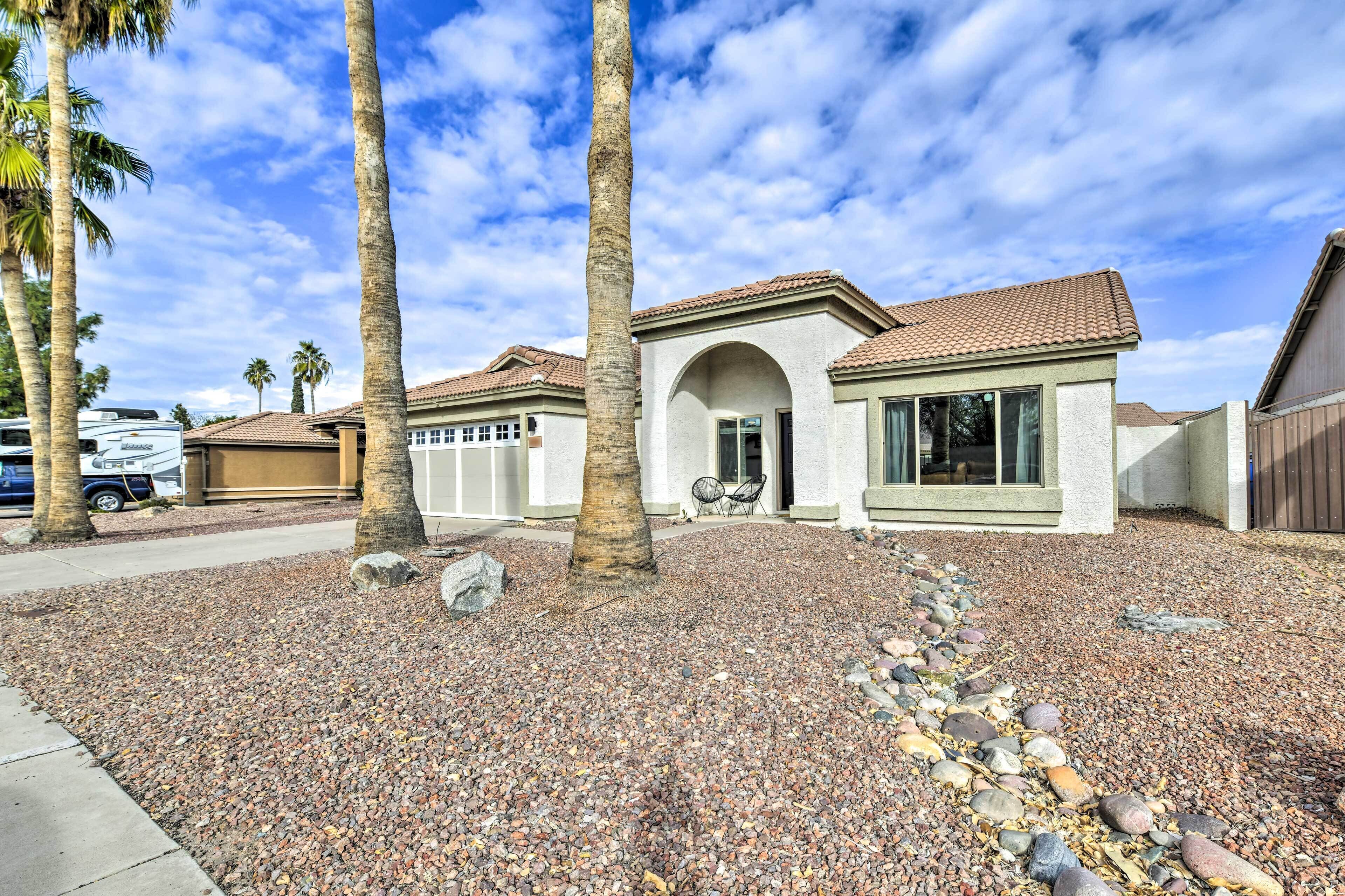 A residential property with a tiled roof, a stone pathway, and palm trees.