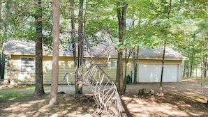 Ein Haus mit Garage, umgeben von Bäumen und einem Garten.